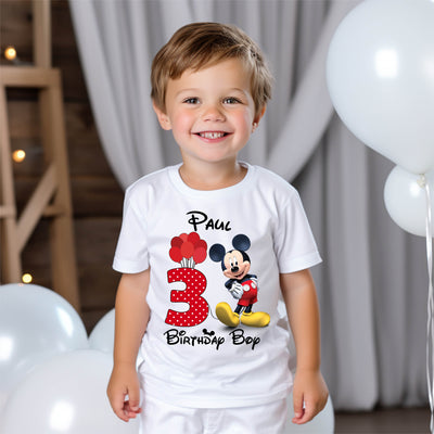 Child wearing a Disney-style mouse birthday t-shirt at a party or celebration.