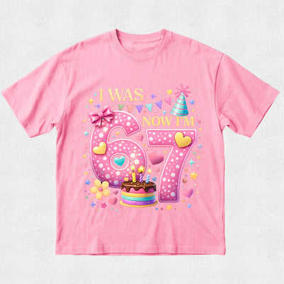 Pink t-shirt with birthday-themed design on a light gray background