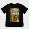 A black short-sleeve t-shirt with a large graphic print on the front depicting a book cover titled 'The Australian Adventure: Starring Camila'. The graphic features an illustration of a young girl in a safari outfit with a koala and a kangaroo, set against a light gray textured background.