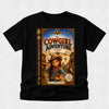 A black short-sleeve t-shirt with a large graphic print of the book cover for 'The Cowgirl Adventure' on the front, displayed against a light gray textured background.