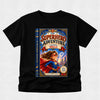 A black short-sleeve crewneck t-shirt featuring a large graphic print of a book cover titled 'The Superhero Adventure' with an illustration of a girl in a superhero costume, displayed on a light gray textured background.
