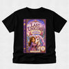 A black short-sleeve t-shirt with a large, colorful graphic print of the book cover for 'The Last Unicorn: Starring Georgie' on the front, displayed against a light gray textured background.