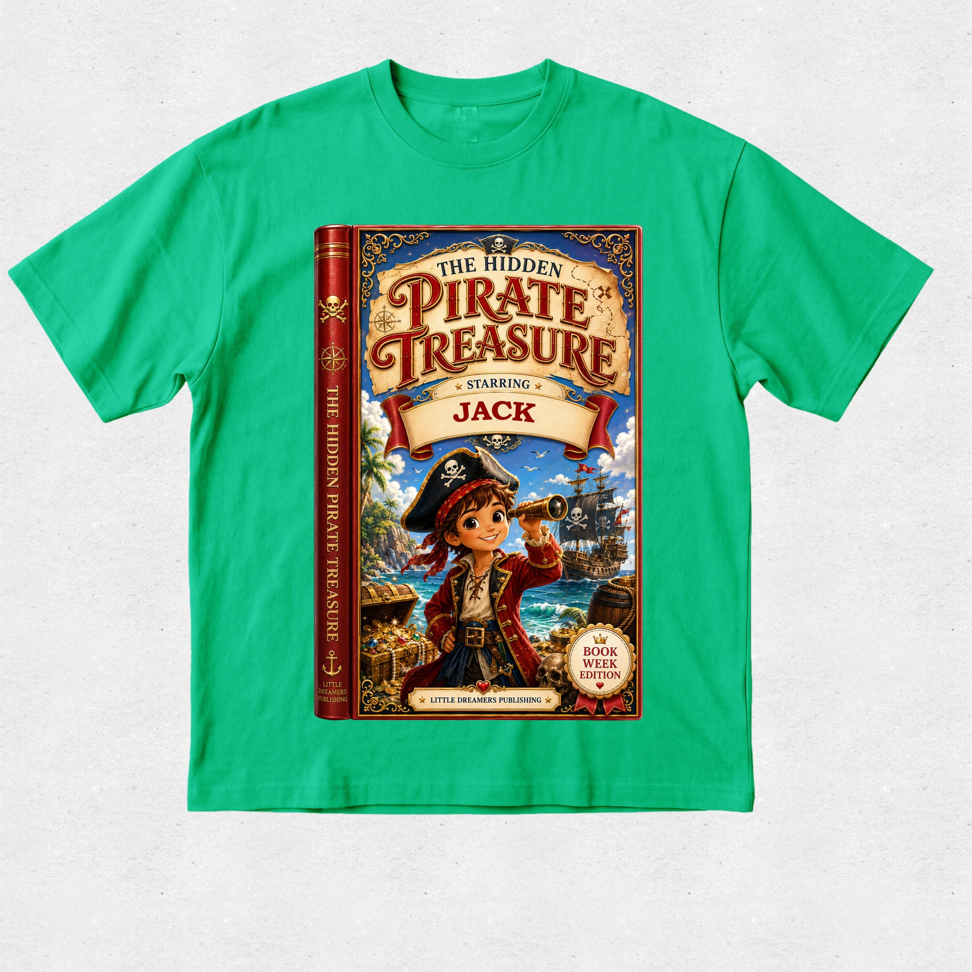 A bright green short-sleeve crewneck t-shirt featuring a large graphic print of the children's book 'The Hidden Pirate Treasure: Starring Jack' on the front, laid flat against a light gray textured background.
