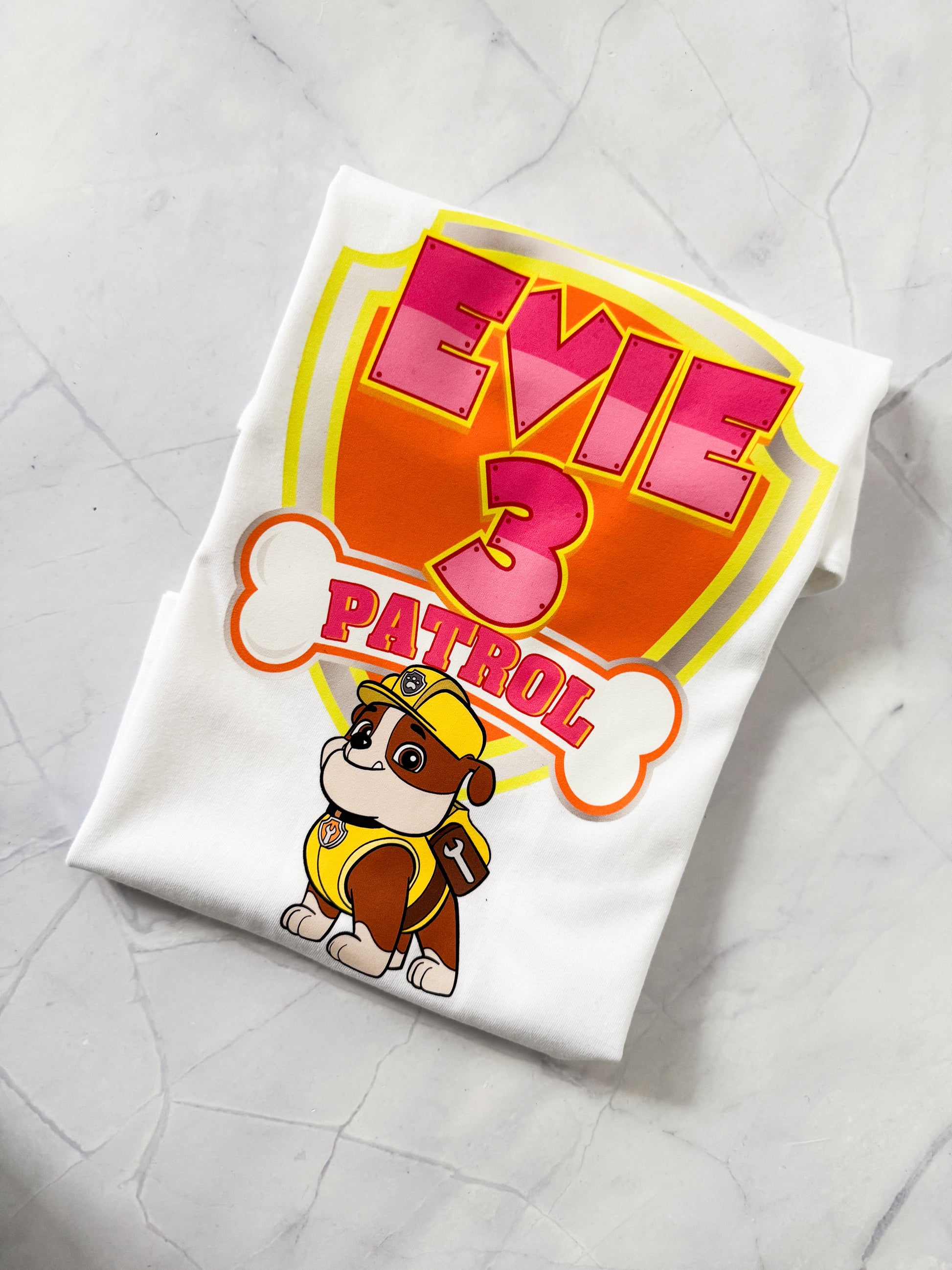 Stacked matching family t-shirts with race car and pup designs for themed birthday celebrations.