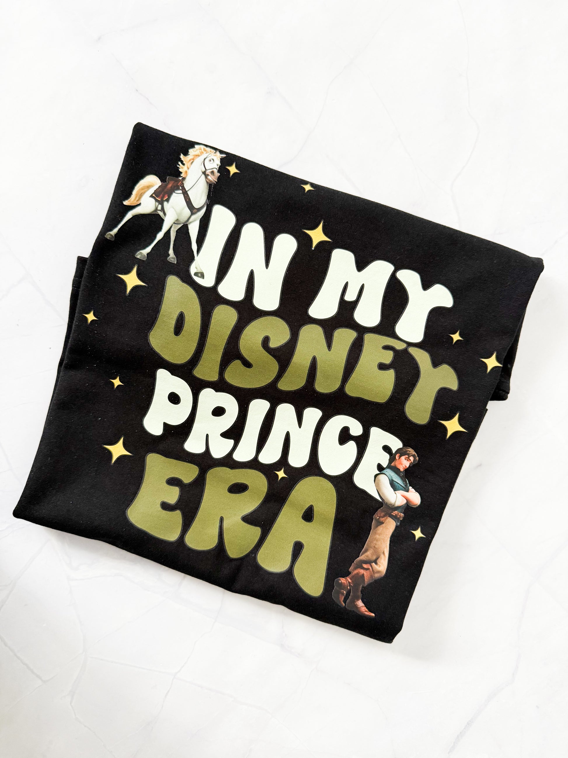 In My Prince Flynn Era Disney-inspired t-shirt displayed flat on black shirt