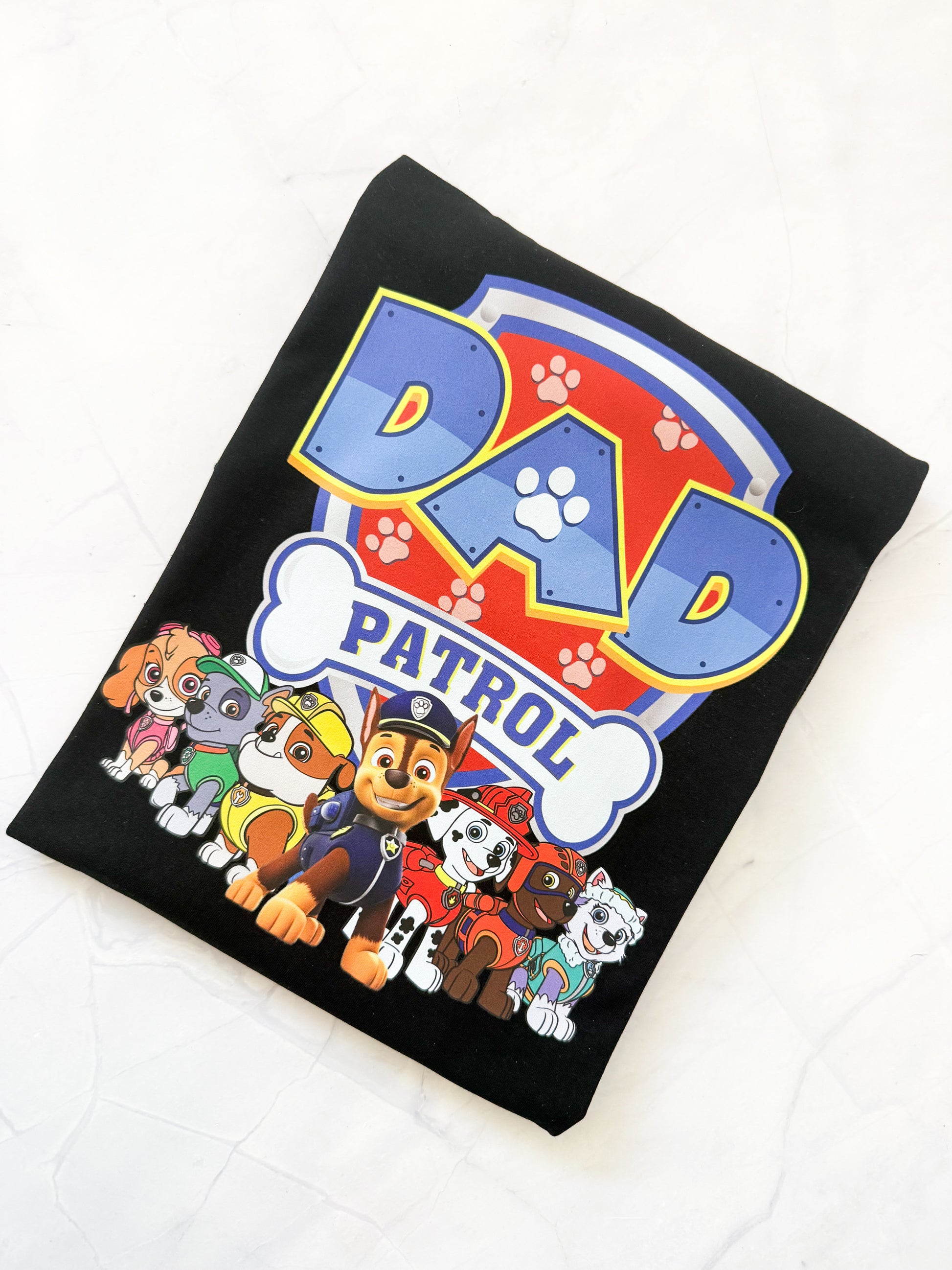 Flat lay of Paw Patrol inspired All Paws on Deck T-shirt showing bright design