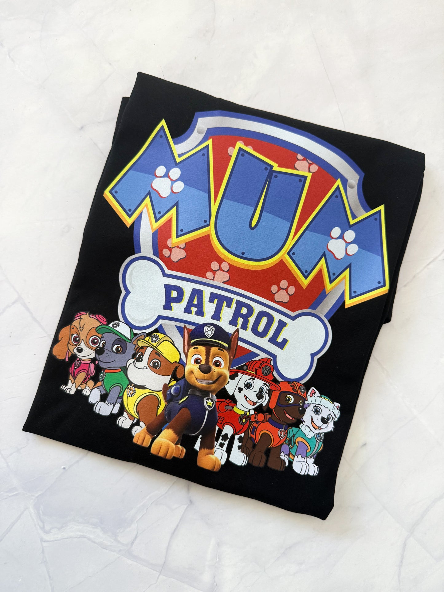 Black blanket with 'Mum Patrol' text and cartoon characters on a white background