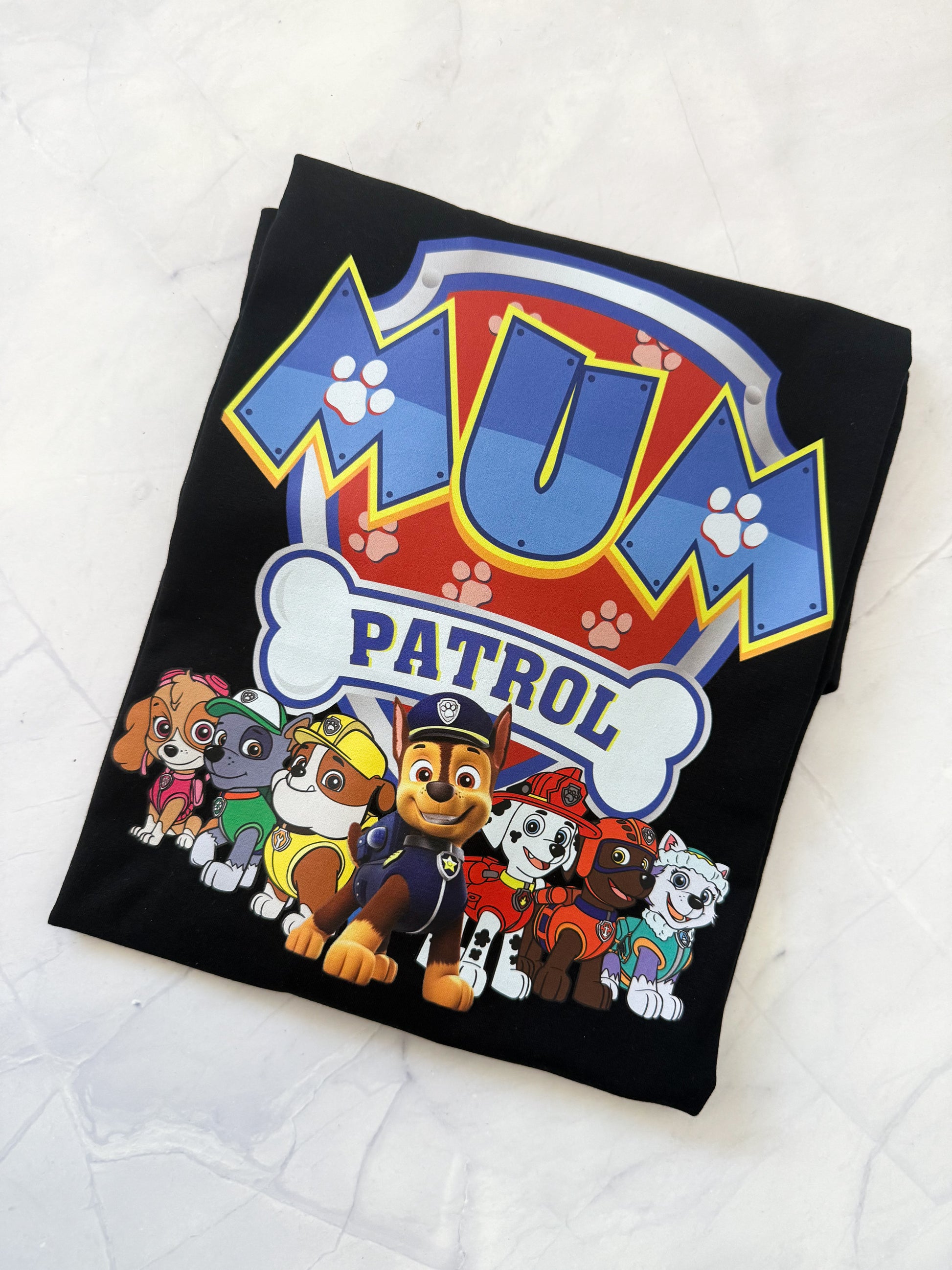 Black blanket with 'Mum Patrol' text and cartoon characters on a white background