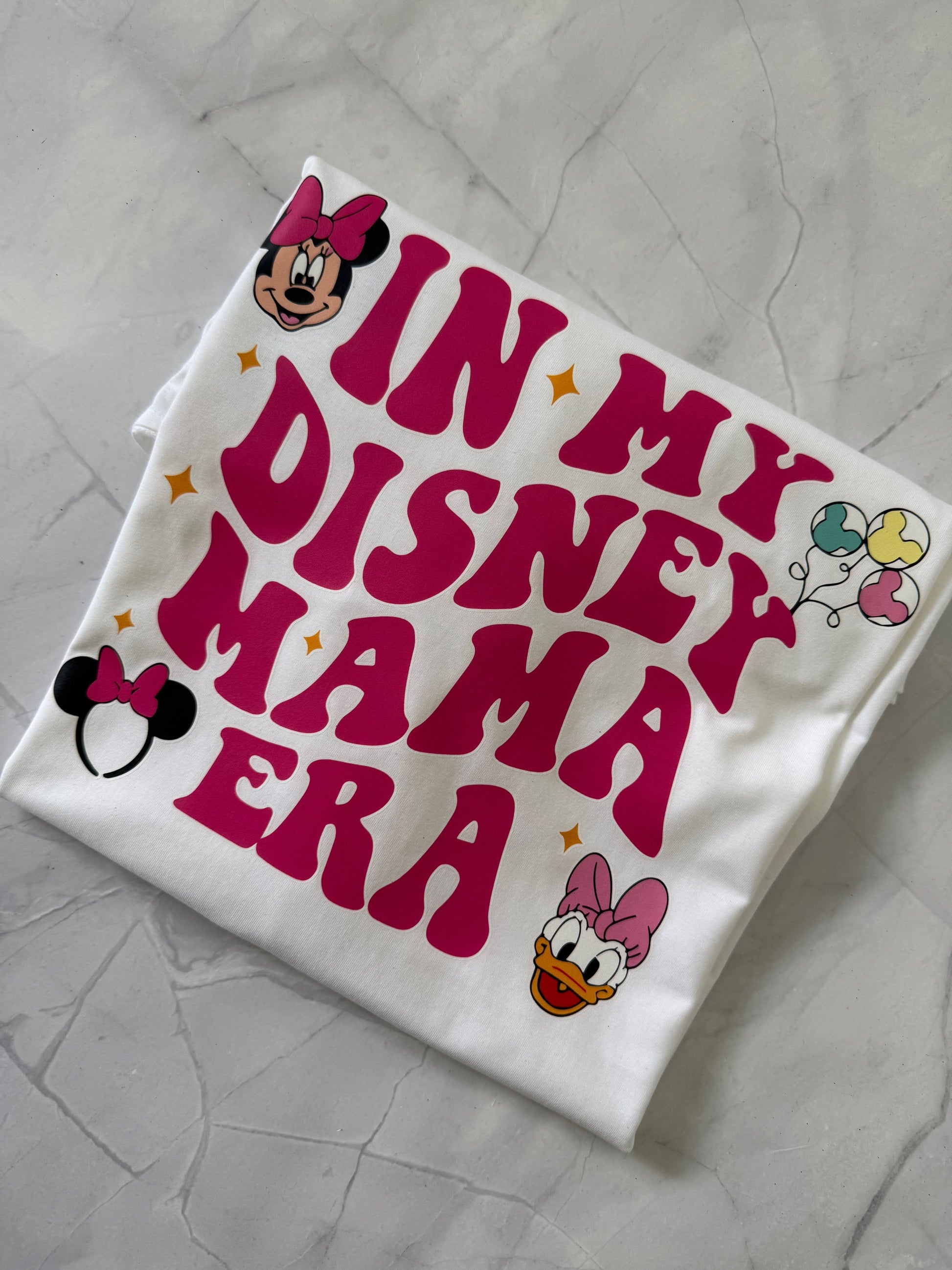 Flat lay of Disney Mama Era shirt styled with jeans and mouse ears for a park-ready outfit