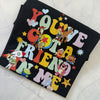 Black t-shirt with colorful cartoon character design on a white surface
