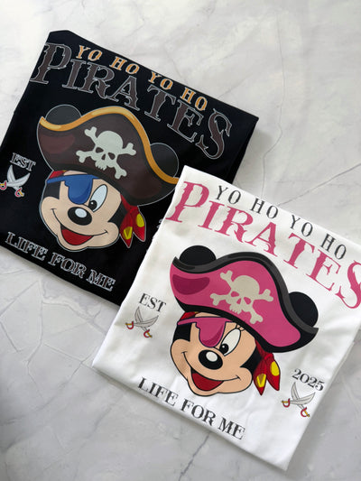 Two pirate-themed t-shirts with cartoon characters Mickey and MInnie on a textured surface