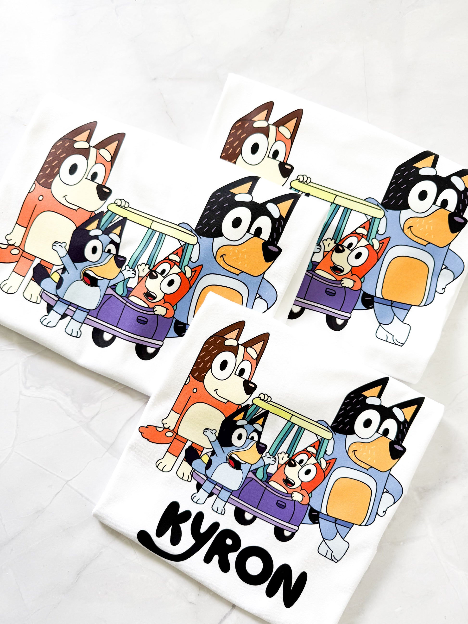Flat lay of custom Bluey-inspired t-shirt featuring Bluey design with personalized name text.