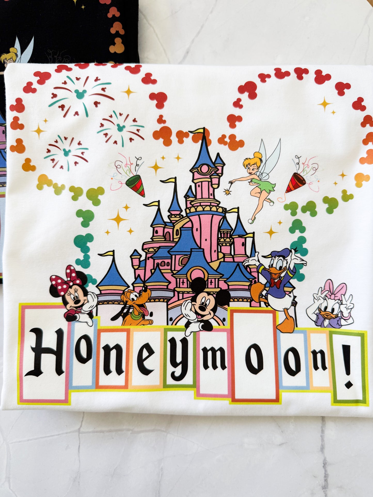 Disney-themed towel with cartoon characters and 'Honeymoon!' text on a white background