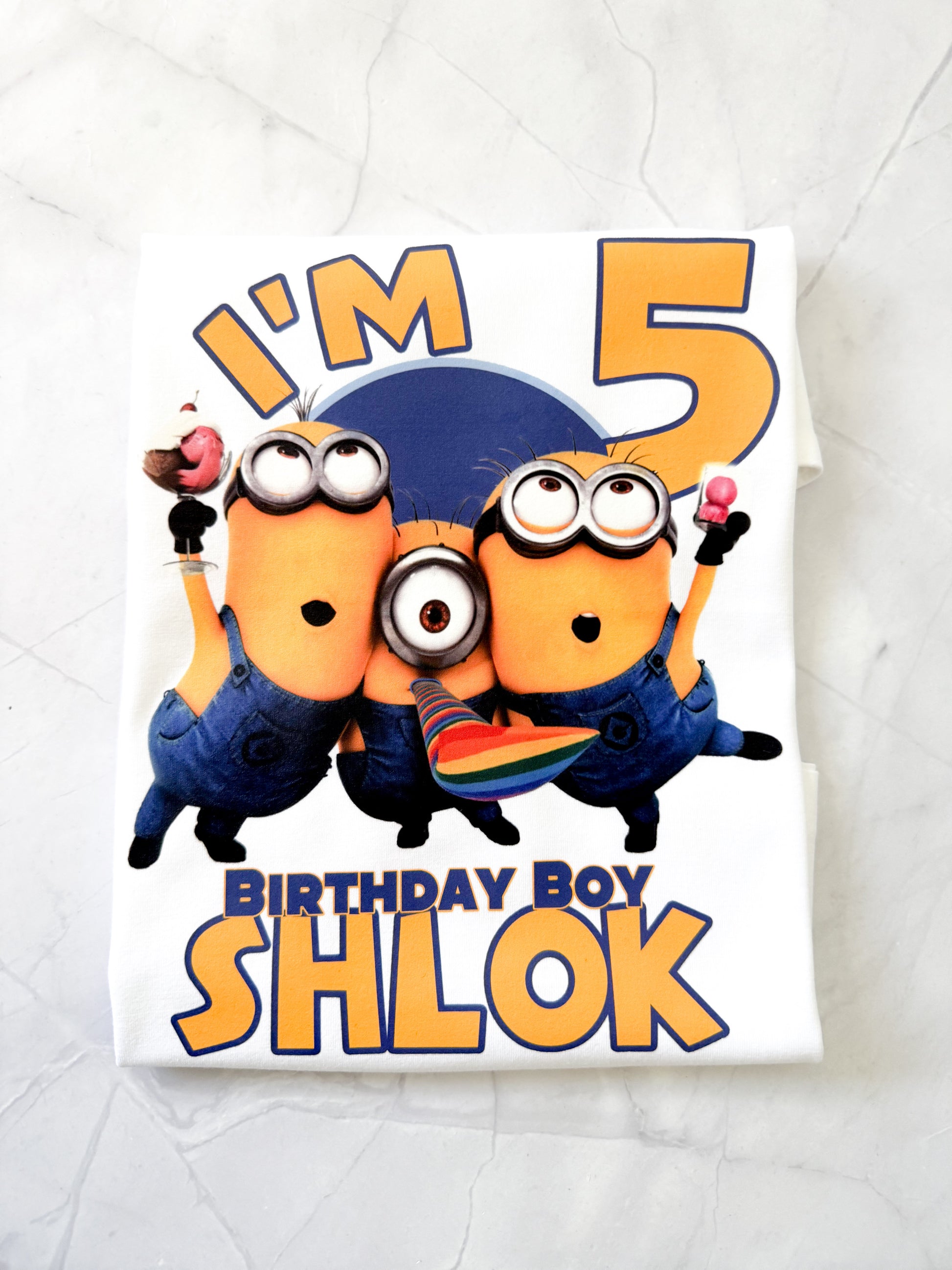 Minions birthday t-shirt folded with party decorations