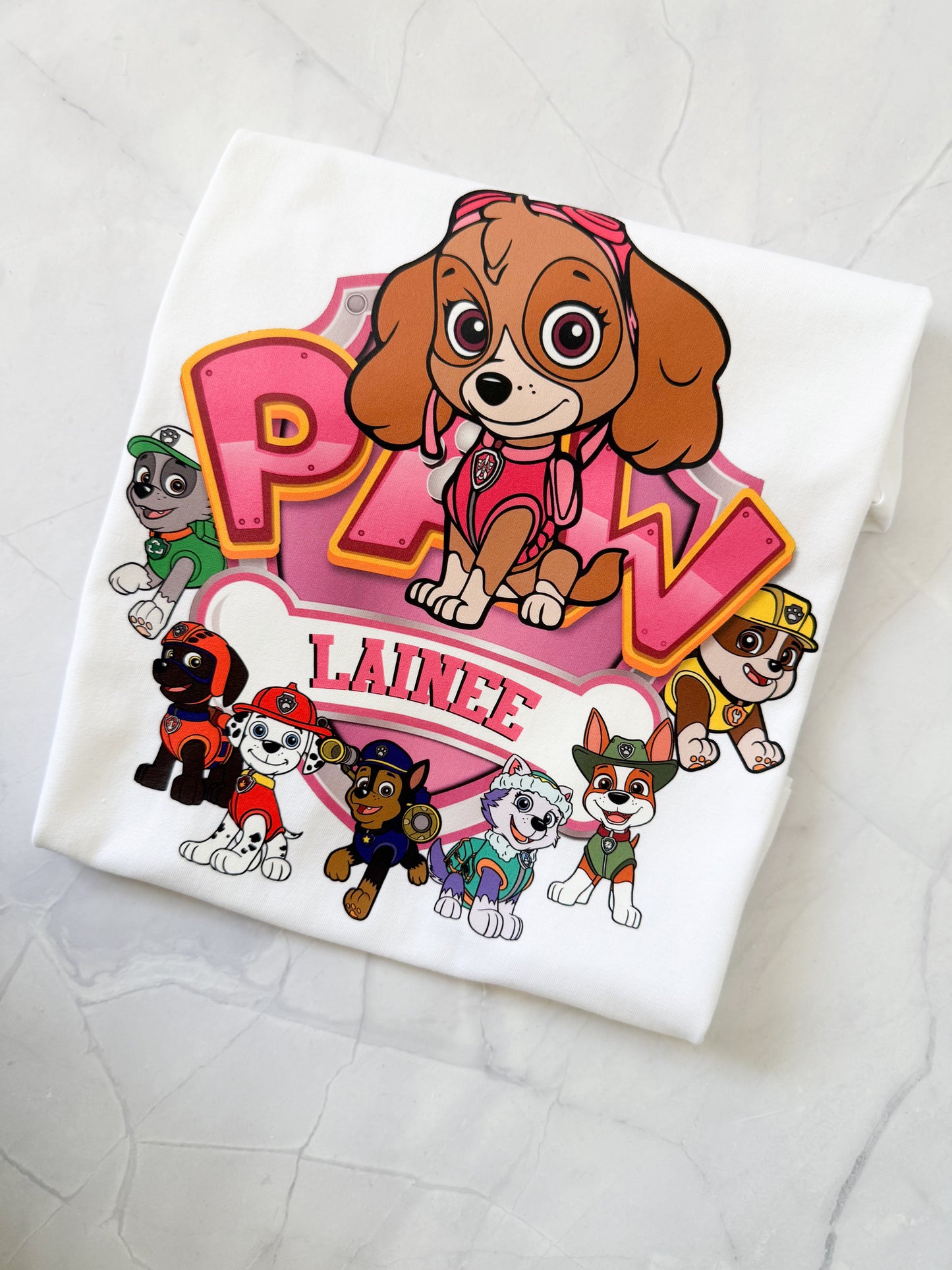 Close-up of Skye character on PAW Patrol themed shirt with pink background and custom name.