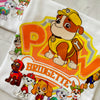 Close-up of Rubble character on birthday shirt with bright yellow "PAW" design and custom name below.