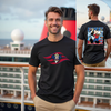 Man wearing a black t-shirt with a colorful graphic design on a cruise ship deck.