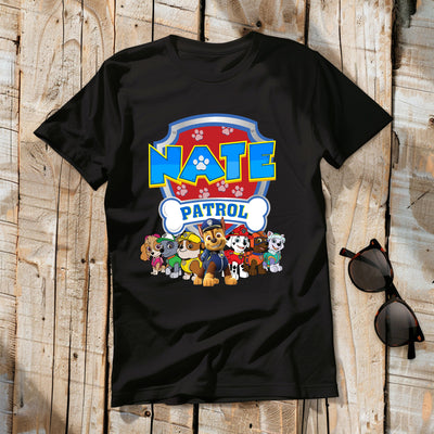 Black t-shirt with 'Nate Patrol' design featuring cartoon characters on a wooden surface.