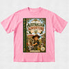 A pink short-sleeve crewneck t-shirt featuring a large graphic print of a children's book titled 'The Australian Adventure' on the front, displayed flat against a light gray textured background.