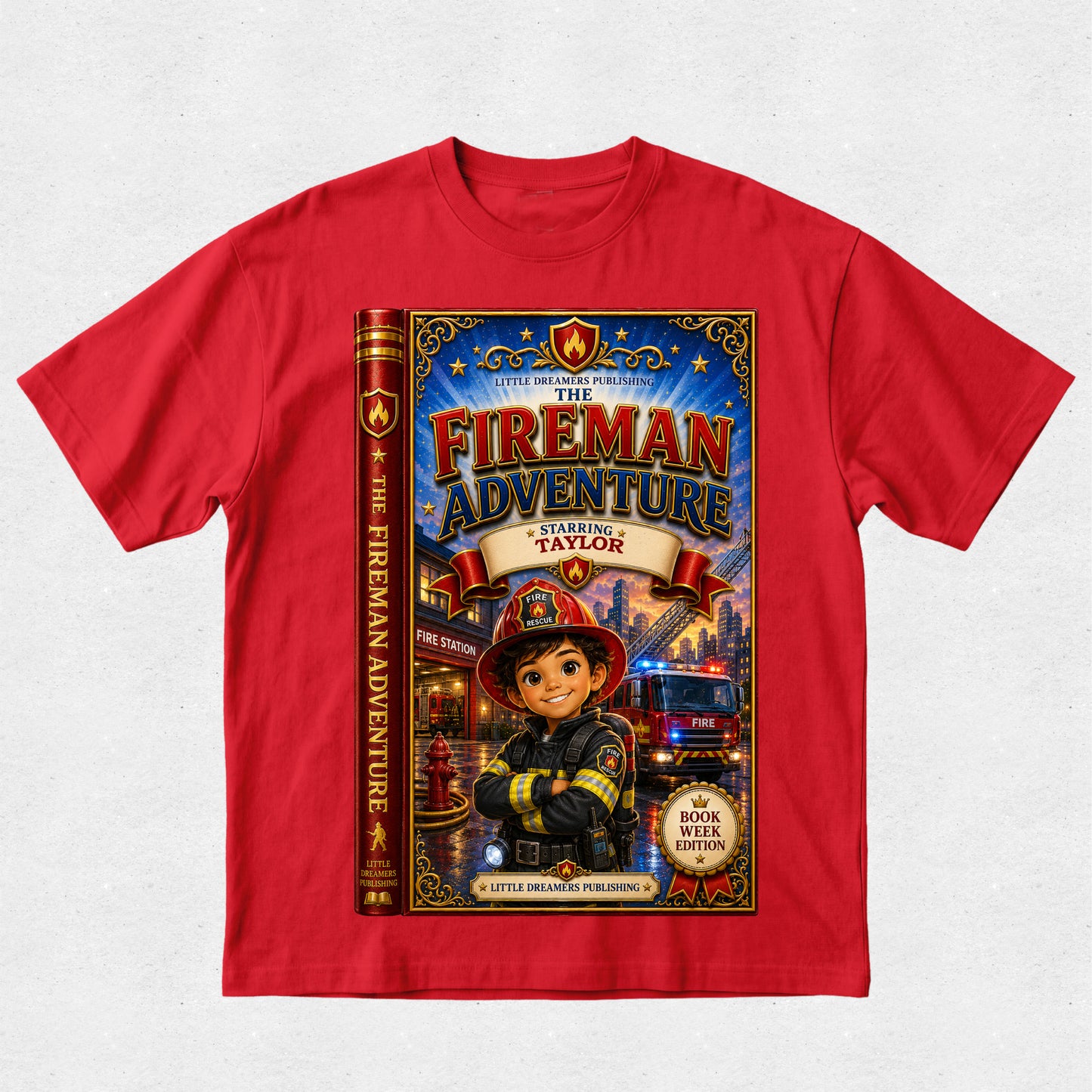 A red short-sleeve crewneck t-shirt featuring a large graphic print of a children's book styled as 'The Fireman Adventure' on the front, displayed against a light gray textured background.