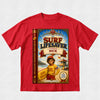 A red short-sleeve crewneck t-shirt featuring a large graphic print of a book cover titled 'The Surf Lifesaver Starring Nick' on the front, displayed against a light gray textured background.