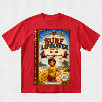 A red short-sleeve crewneck t-shirt featuring a large graphic print of a book cover titled 'The Surf Lifesaver Starring Nick' on the front, displayed against a light gray textured background.