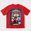 A red short-sleeve crewneck t-shirt featuring a large graphic print of a children's book styled as 'The Superhero Adventure' starring Paul, displayed on a light gray textured background.