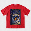 A red short-sleeve crewneck t-shirt featuring a large graphic print of a children's book titled 'Lost in Space' on the front. The graphic shows a dark blue book cover with an astronaut character, stars, and the text 'Starring Adrian'.