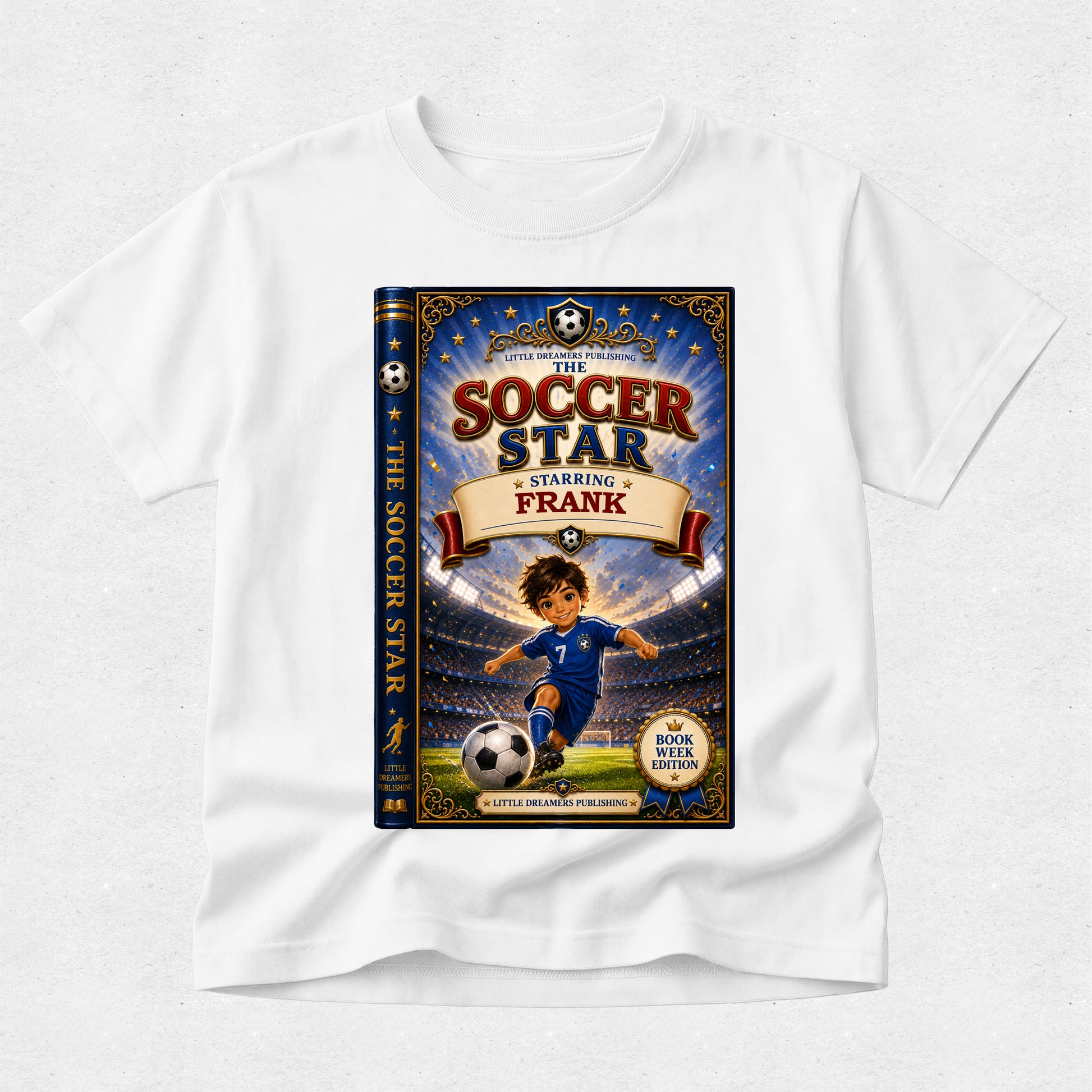 A white short-sleeve crewneck t-shirt featuring a large graphic print of the book cover for 'The Soccer Star Starring Frank' on the front, displayed against a light gray textured background.