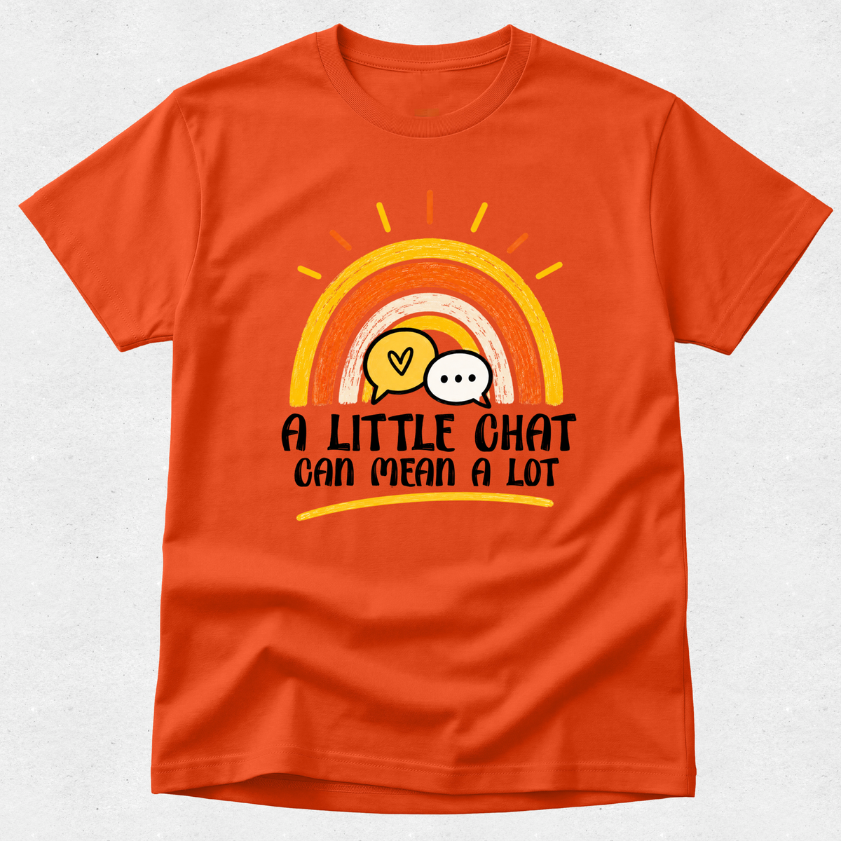 An orange short-sleeve crewneck t-shirt with a retro rainbow graphic and the text 'A LITTLE CHAT CAN MEAN A LOT' printed on the front, displayed against a light gray textured background.