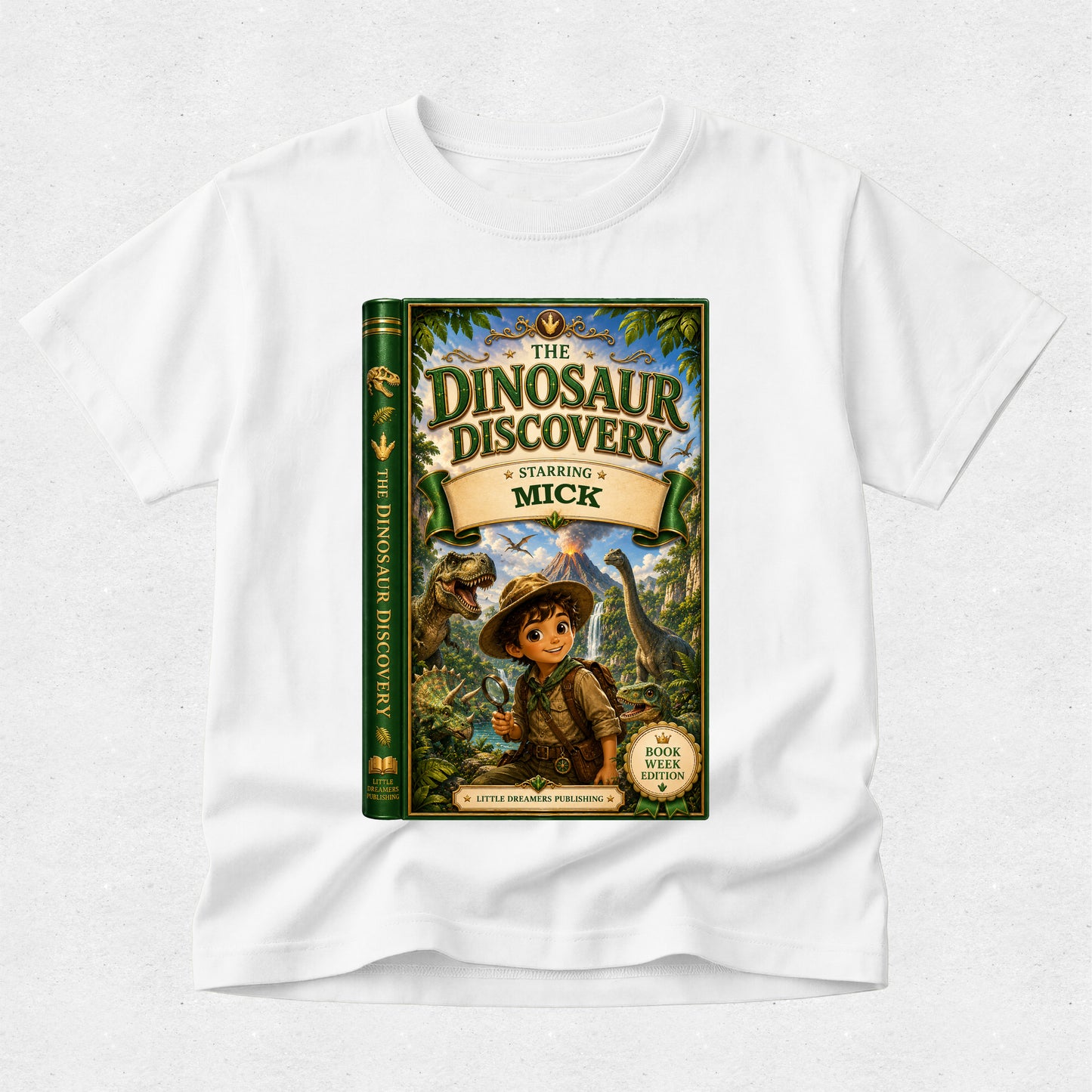 A white short-sleeve crewneck t-shirt featuring a large graphic print of the book cover for 'The Dinosaur Discovery: Starling Mick' on the front, displayed against a light gray textured background.