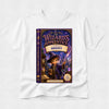 A white short-sleeve crewneck t-shirt featuring a large, colorful graphic print of the book cover for 'The Wizard's Apprentice: Charming Brent' on the front, displayed against a light gray textured background.