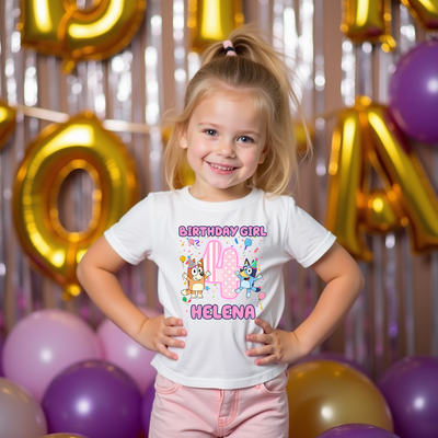 Young girl wearing a 'Birthday Girl' shirt with colorful graphics and text, standing in front of balloons and decorative letters.