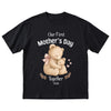 Black t-shirt with teddy bear design and 'Our First Mother's Day Together 2026' text on a white background