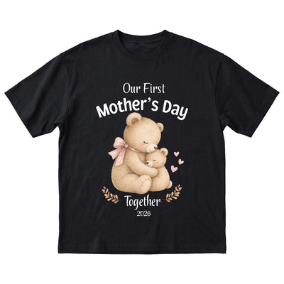 Black t-shirt with teddy bear design and 'Our First Mother's Day Together 2026' text on a white background