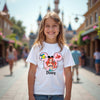 Young girl wearing a Disney-themed t-shirt with a castle in the background