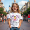 Young girl wearing a Disney t-shirt with a character design in a theme park setting