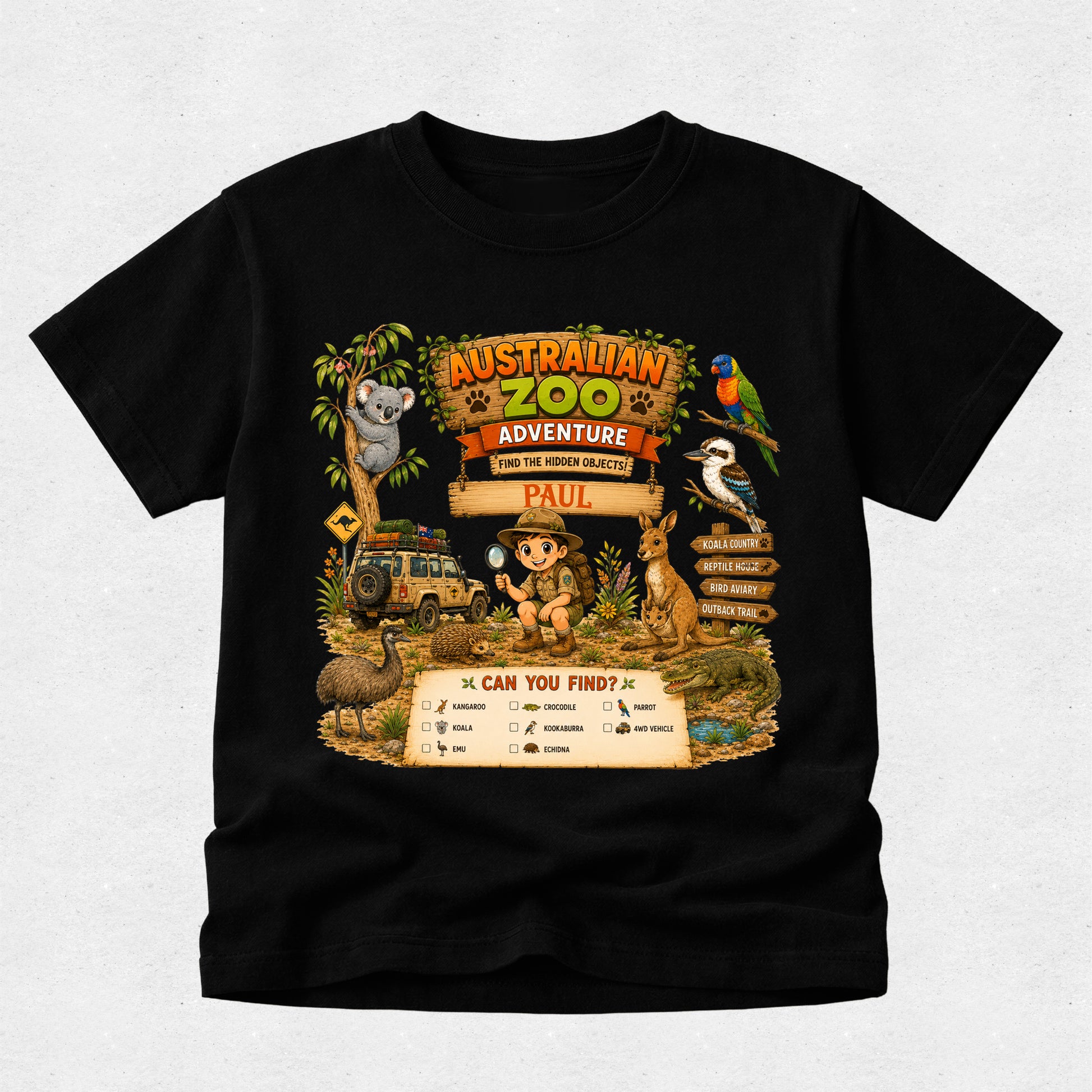 A black short-sleeve t-shirt with a colorful graphic print of an Australian Zoo theme, featuring a cartoon koala, kangaroo, parrot, and safari vehicle, with a personalized name 'PAUL' on a sign.