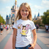 Young girl wearing a Disney-themed t-shirt with a castle in the background