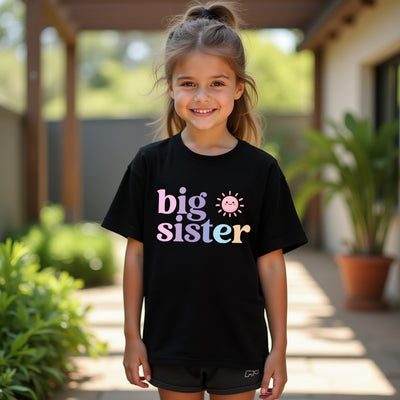 Young girl wearing a black 'big sister' t-shirt outdoors.