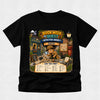 A black short-sleeve t-shirt with a large, colorful graphic print on the front depicting a cartoon detective character in a hat and coat, holding a magnifying glass in front of a 'Book Week Quest Detective Agency' sign. The shirt is displayed flat against a light gray textured background.