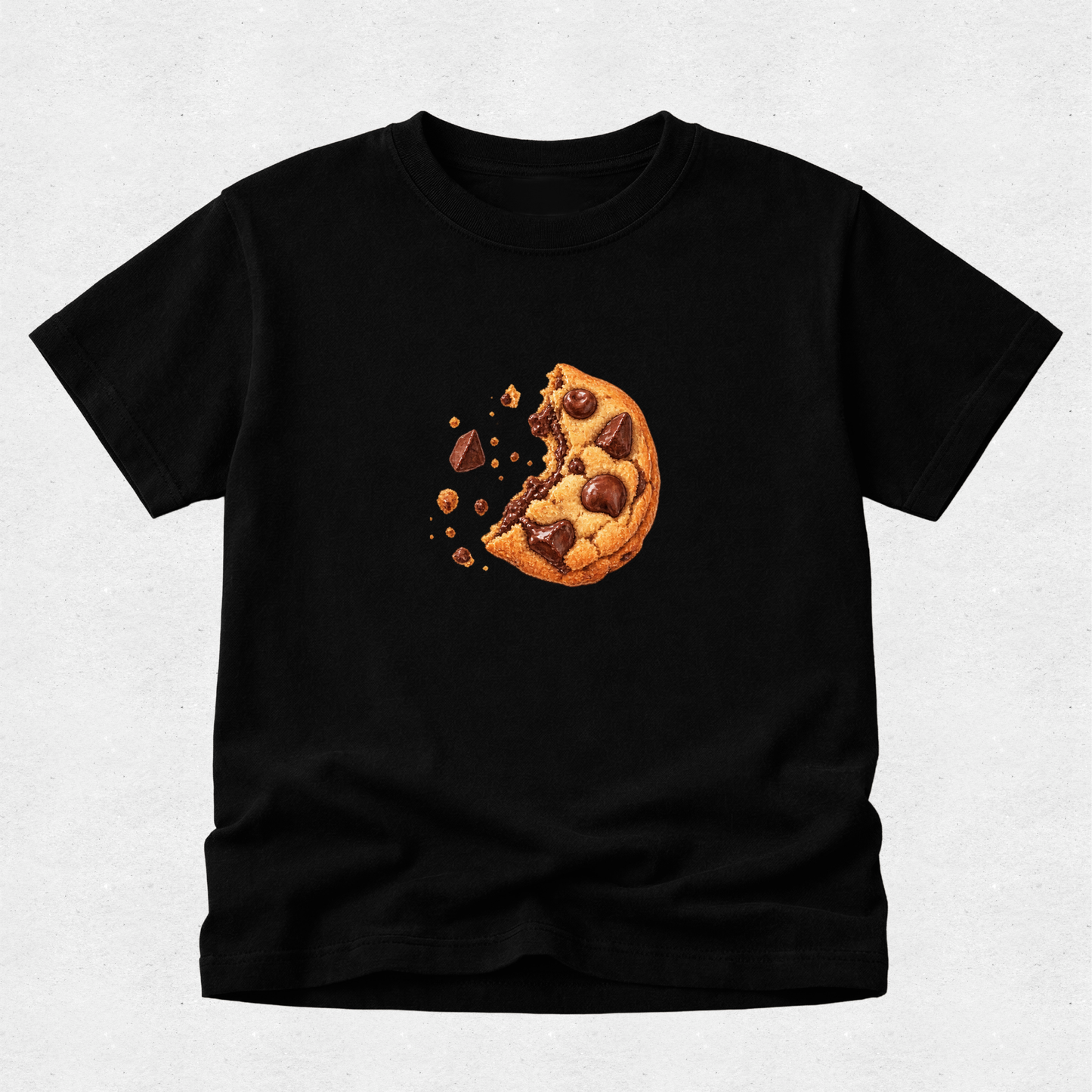 A black short-sleeve crewneck t-shirt featuring a graphic print of a partially eaten chocolate chip cookie with crumbs, displayed on a light gray textured background.