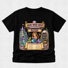 A black short-sleeve t-shirt with a colorful graphic print on the front. The graphic features a mermaid, a castle, a library, and scrolls reading 'BOOK WEEK QUEST', 'MERMAID COVE', and 'ALEXIA', along with a checklist at the bottom.