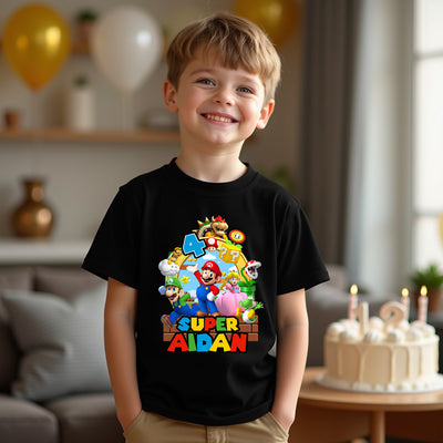 Child wearing a black t-shirt with colorful graphics and text, standing in a room with balloons and a cake.