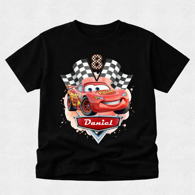 Black t-shirt with a cartoon car design and 'Daniel' on a light gray background