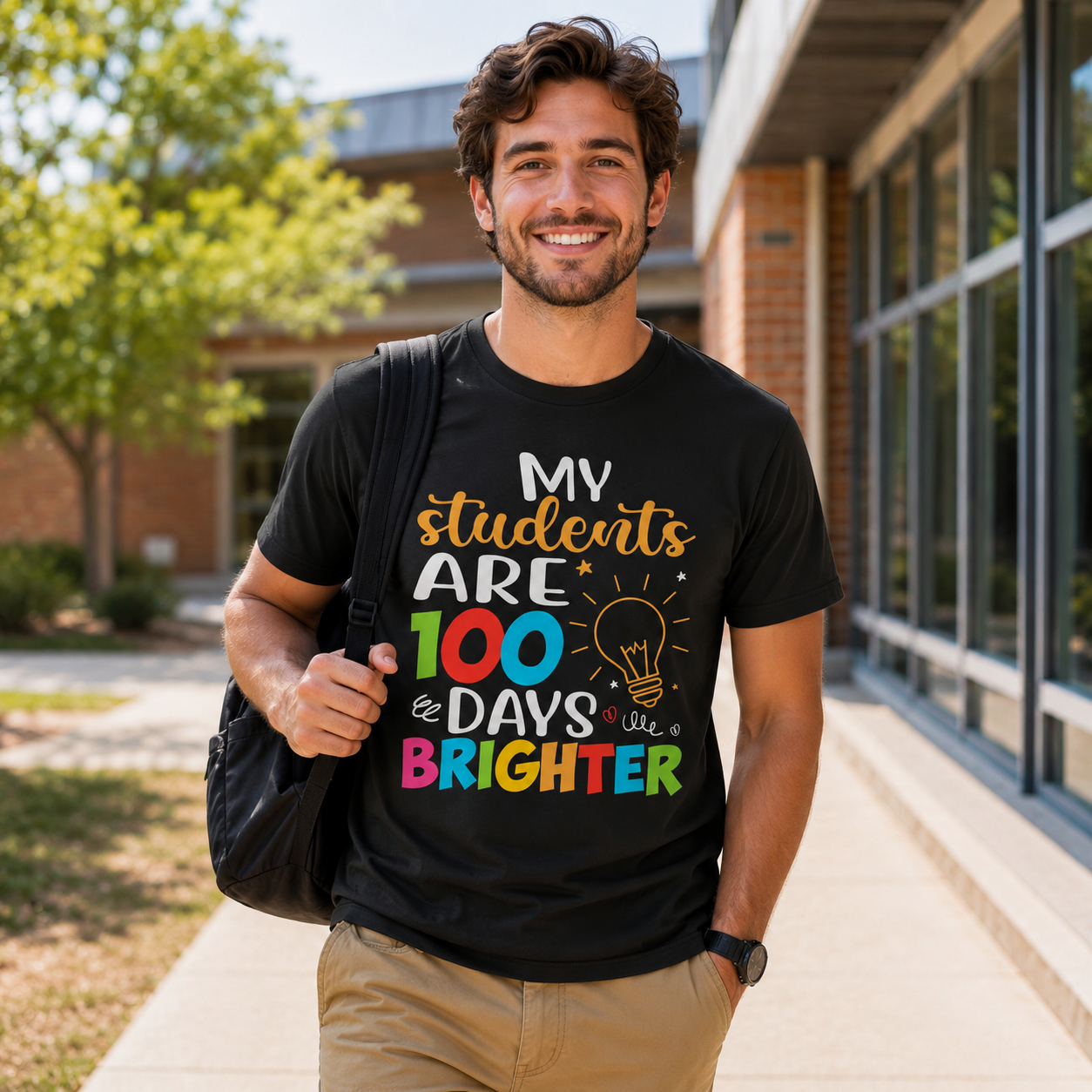 Man wearing a black t-shirt with colorful text standing outside a building