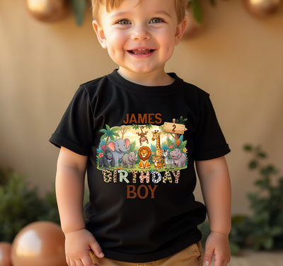 Child wearing a black t-shirt with a birthday-themed design, standing against a blurred background.