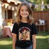 Young girl wearing a black t-shirt with a graphic design outdoors.