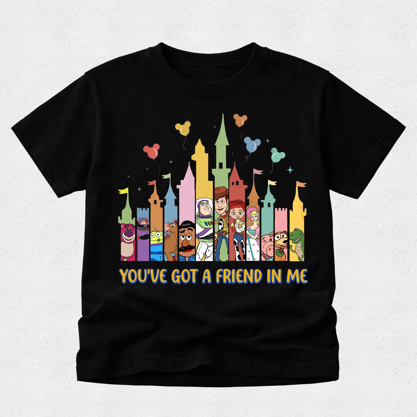Black t-shirt with colorful cartoon characters and castle design on a light gray background