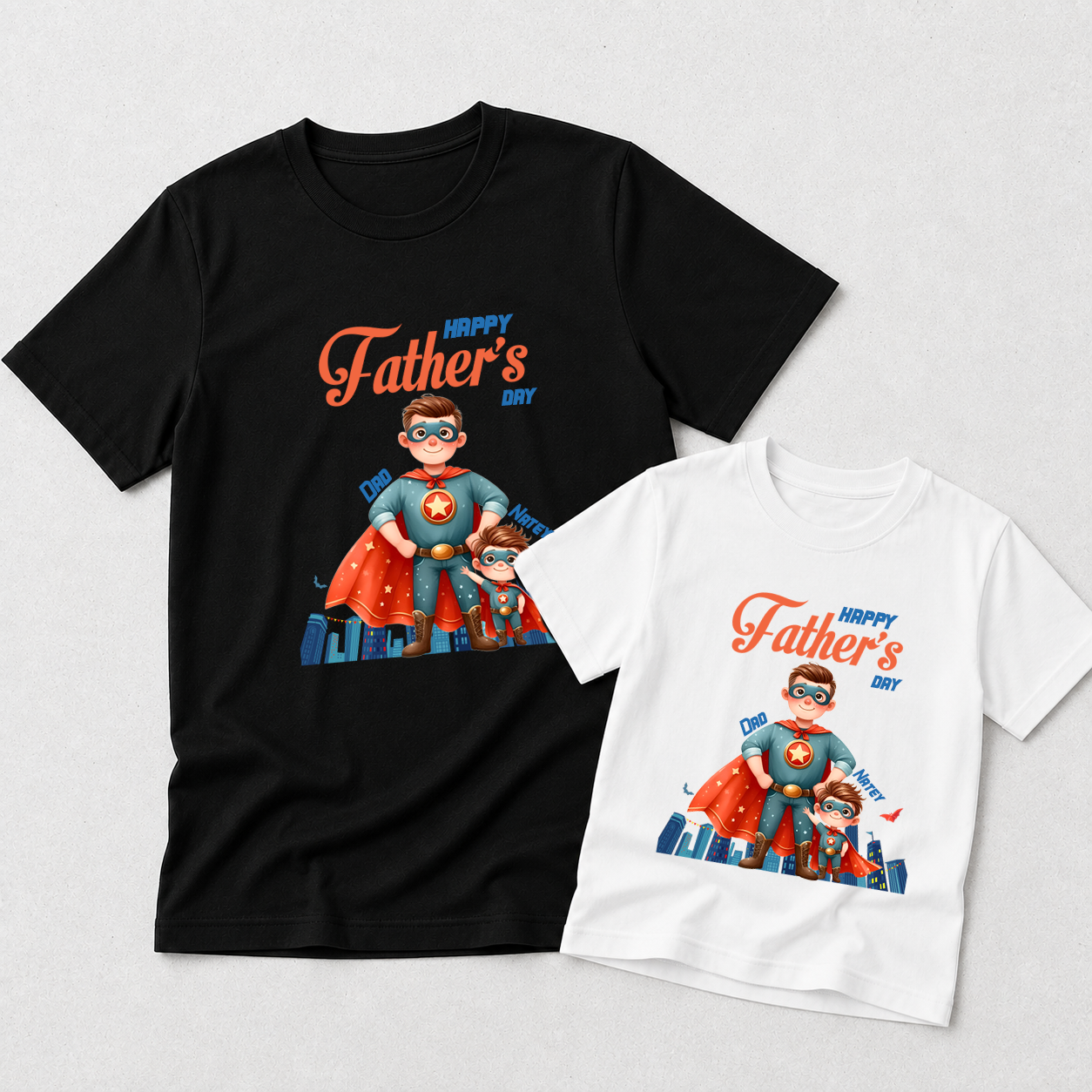 Two Father's Day graphic T-shirts shown on a light gray background: a black adult-sized shirt and a white child-sized shirt, both featuring a colorful superhero illustration and the text 'Happy Father's Day'.